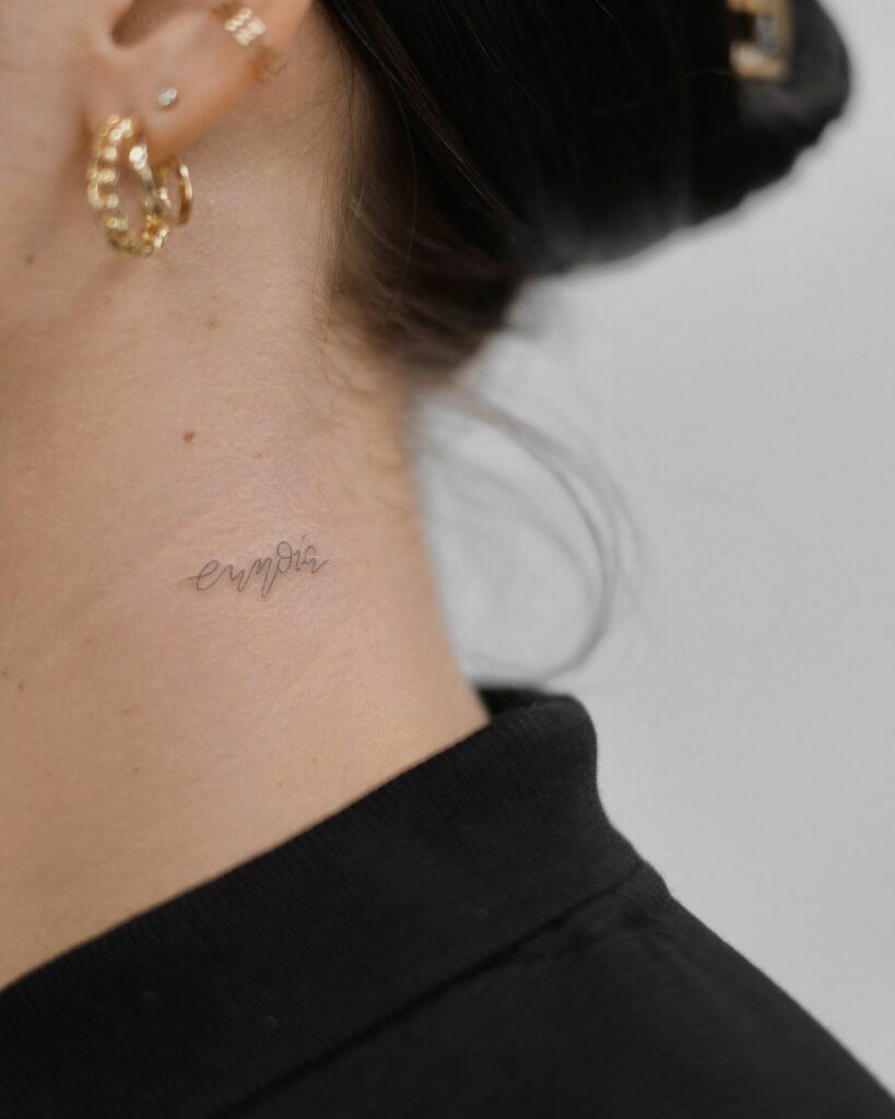 Tiny, stylish handwritten lettering tattoo on the side neck "eunoia" grace
