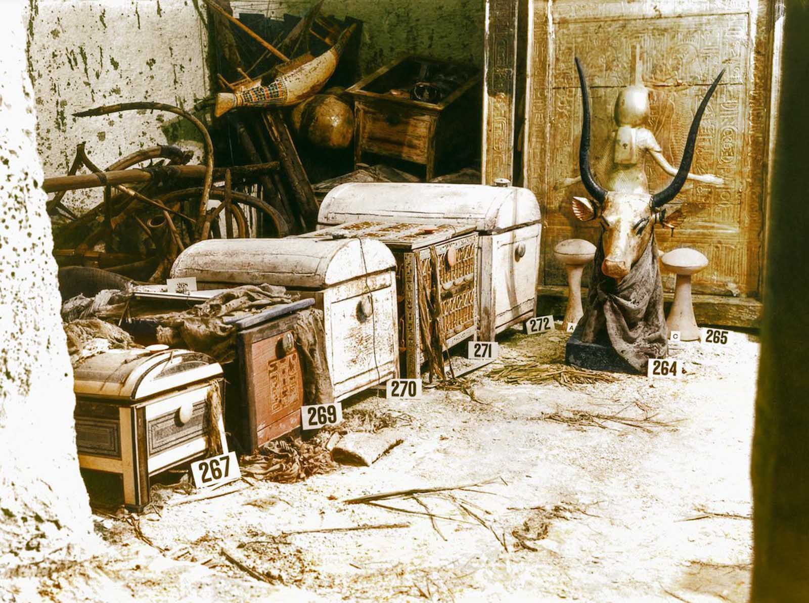 A gilded bust of the Celestial Cow Mehet-Weret and chests sit in the treasury of the tomb.