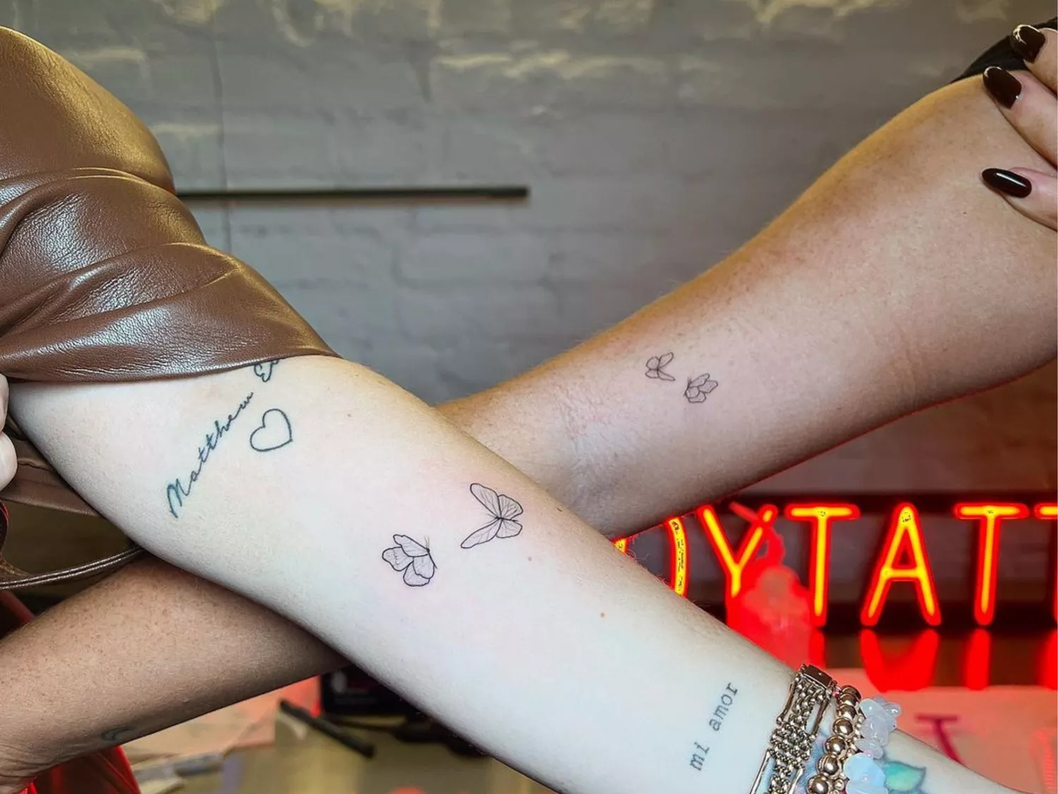 Close up of two arms with matching butterfly tattoos