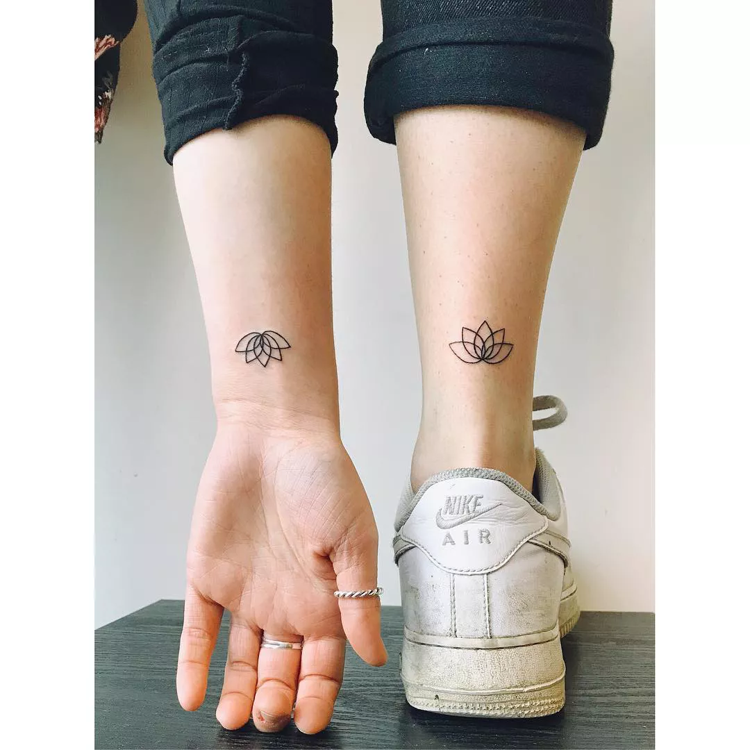 Close up of an arm and leg with matching lotus tattoos