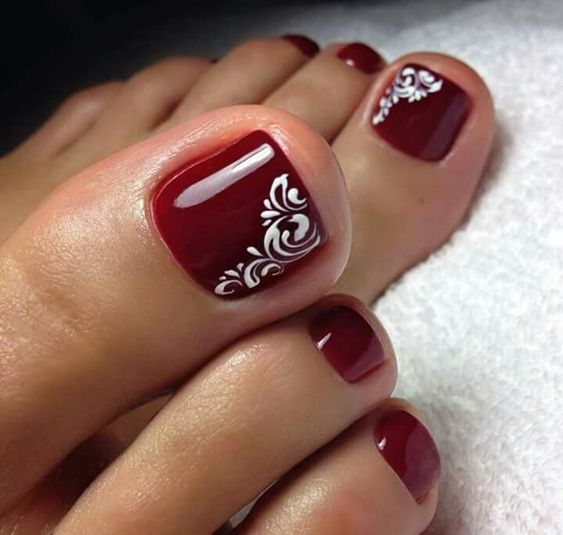 Simple red /burgundy toe nails with swirl accent