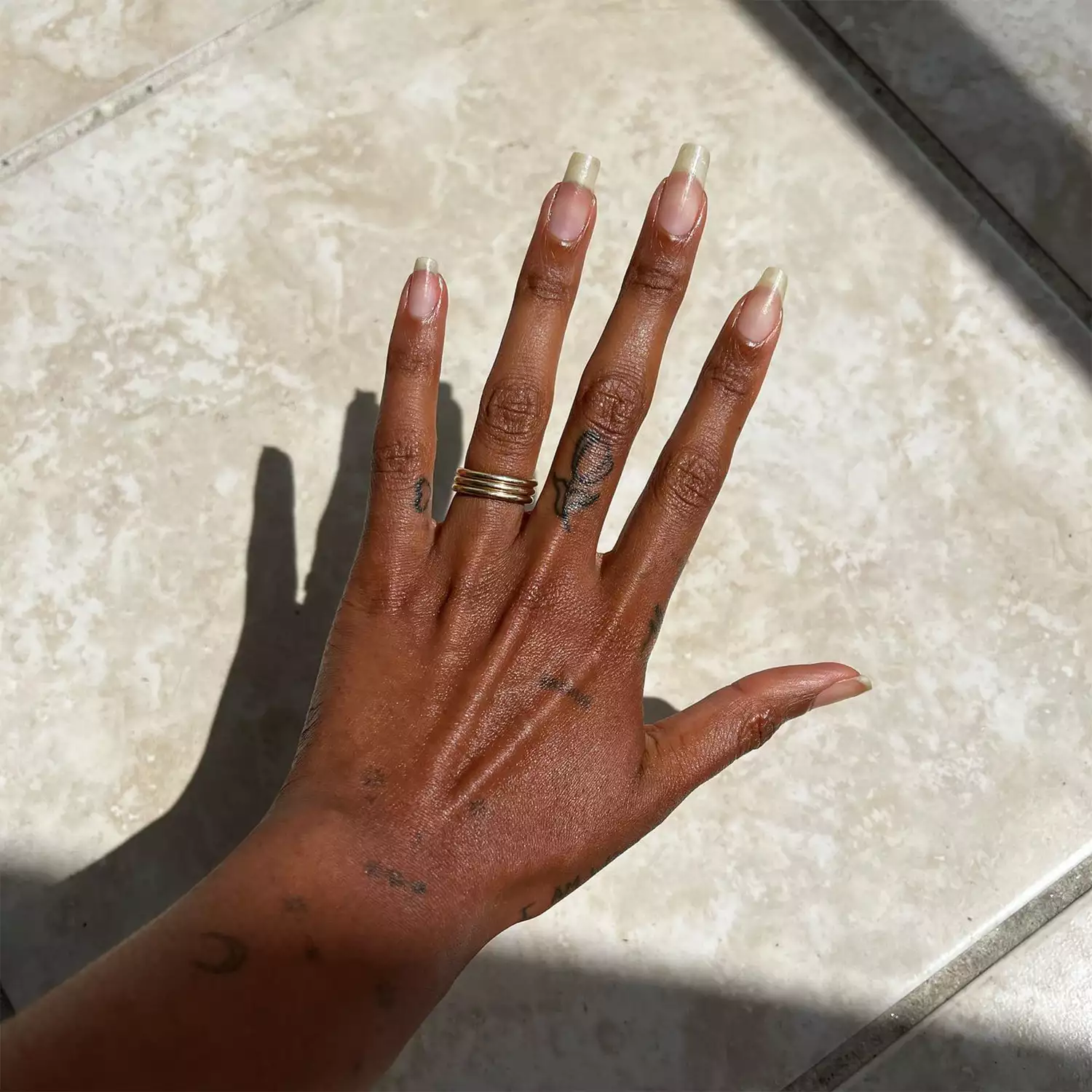 woman's hand with small heart tattoo on pinky