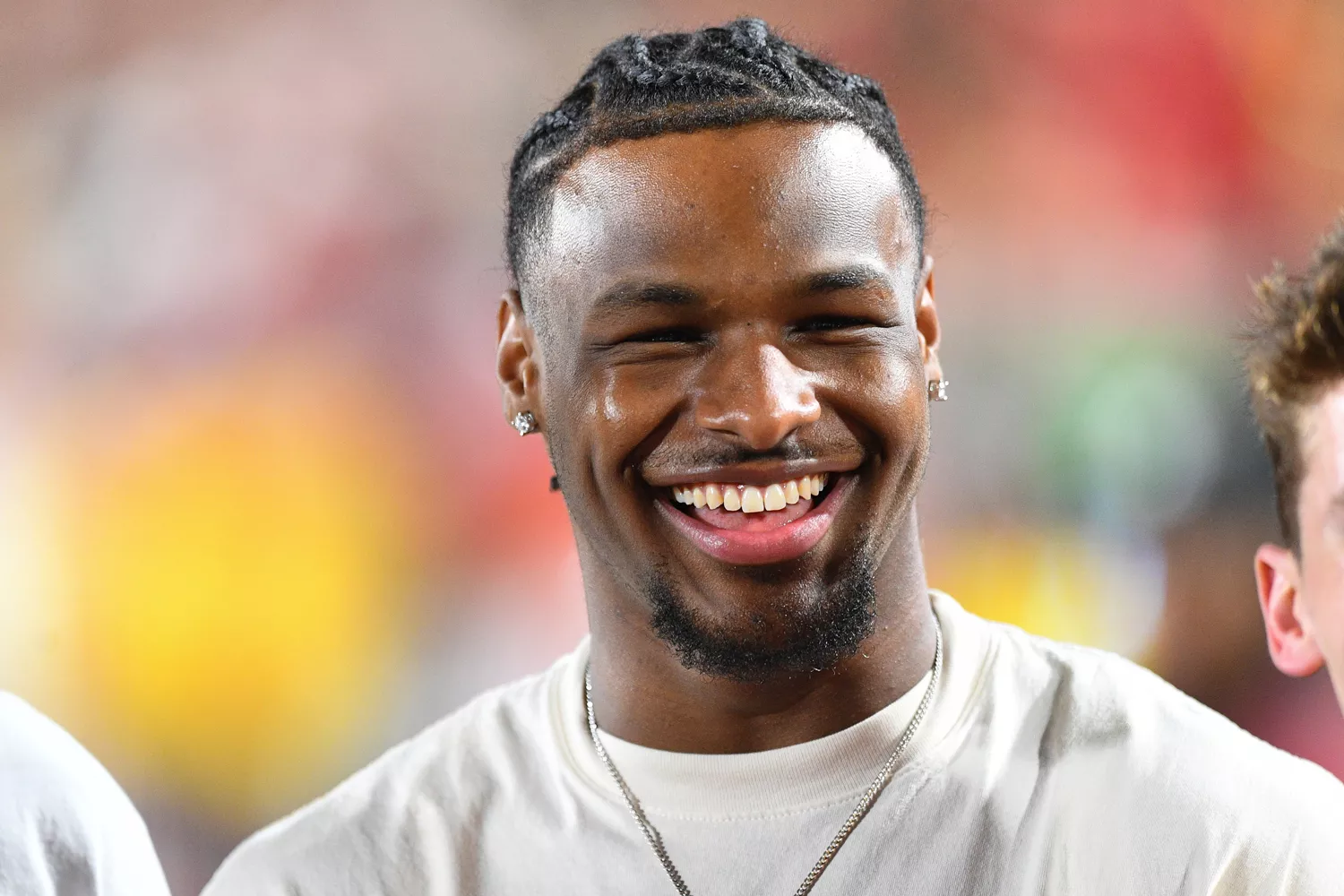 USC basketball player Bronny James jokes around on the sidelines during a game between the San Jose State Spartans and the USC Trojans on August 26, 2023