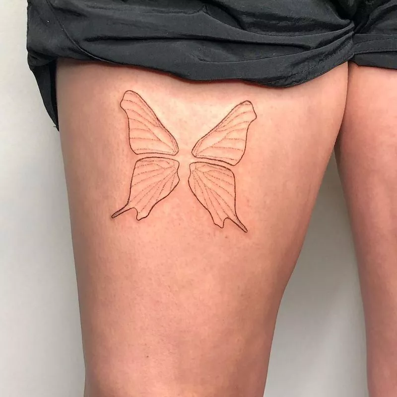 Big butterfly wing tattoo on upper thigh