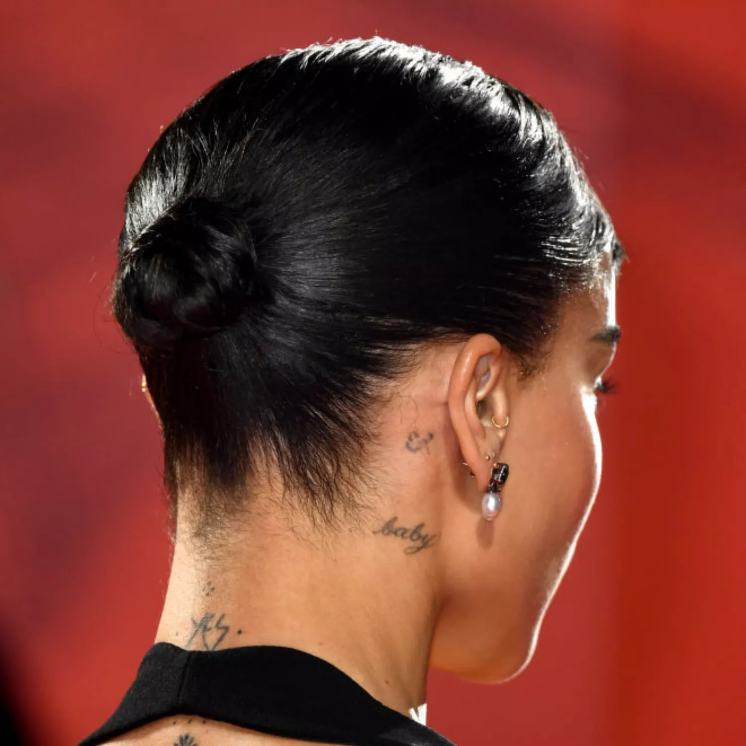 zoomed-in photo of Zoe Kravitz with baby script tattoo behind the ear