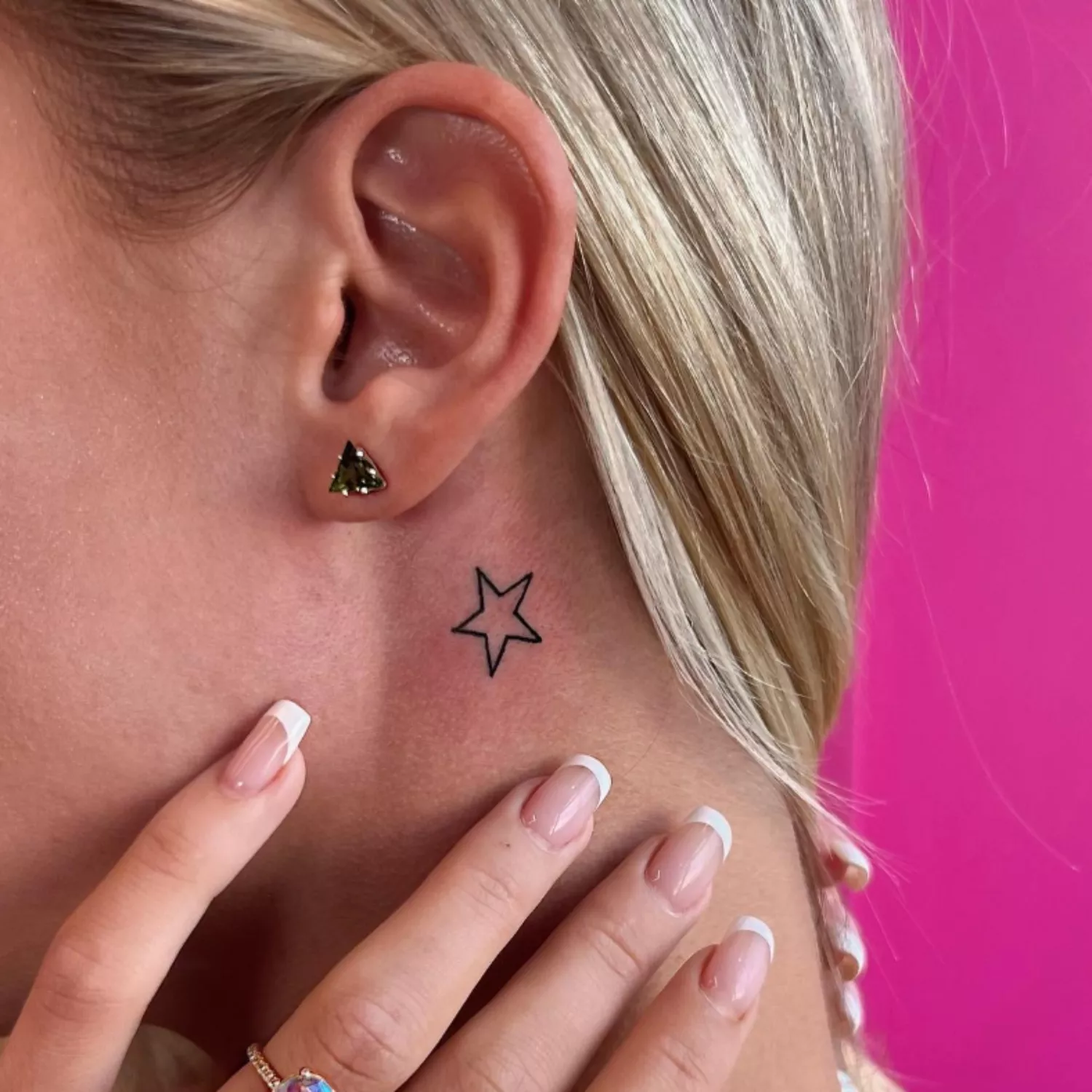 zoomed-in photo of person with star tattoo behind the ear