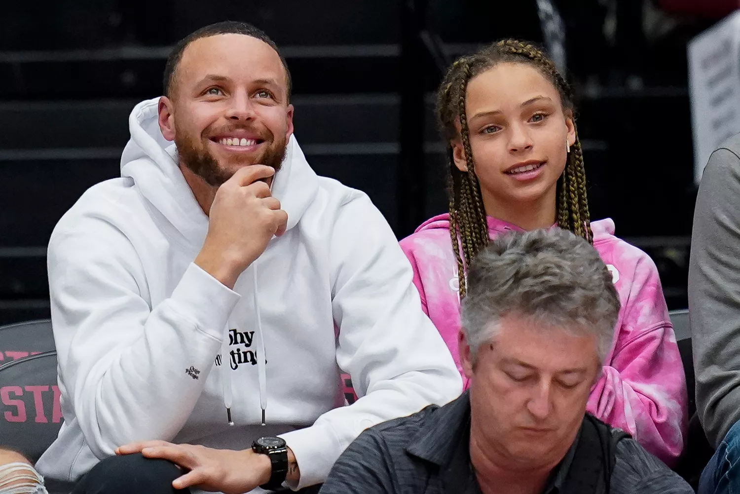 Golden State Warriors' Stephen Curry, second from right, and his daughter Riley, right, sit courtside during the first half of an NCAA college basketball game between Stanford and Southern California in Stanford, Calif., Friday, Feb. 17, 2023. (AP Photo/Godofredo A. Vásquez)