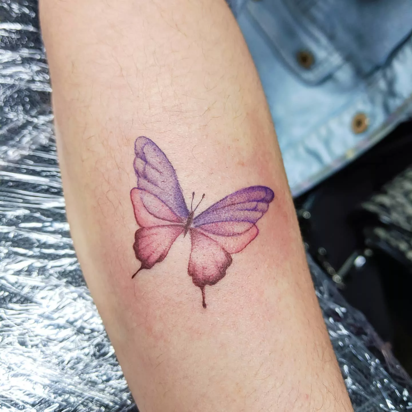 Close up of purple and pink butterfly tattoo