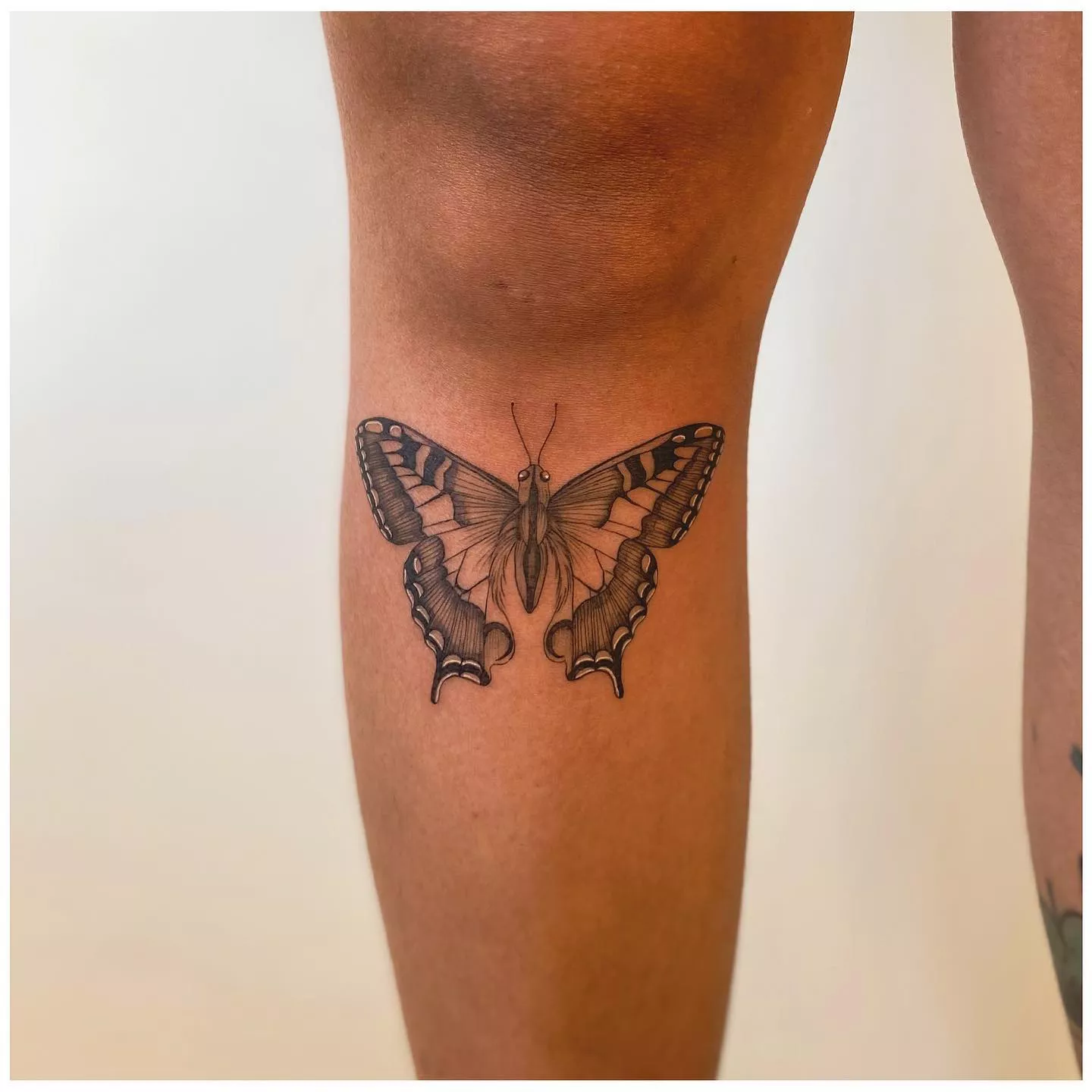 Close up of butterfly tattoo below the knee