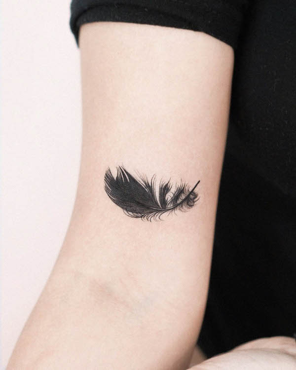 Intricate black feather tattoo by @hansantattoo