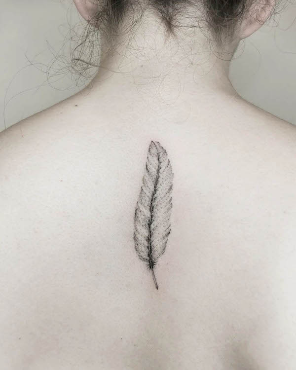 Simple feather back tattoo by @sibyllatattoo