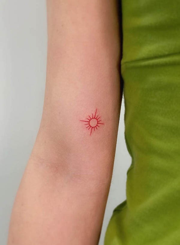 Simple red fine line sun tattoo by @cha.tattoo