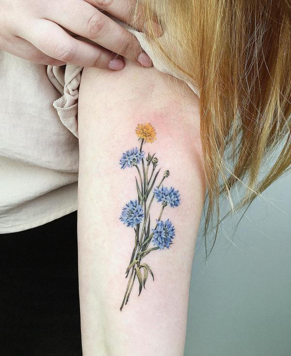Blue and yellow cornflower arm tattoo