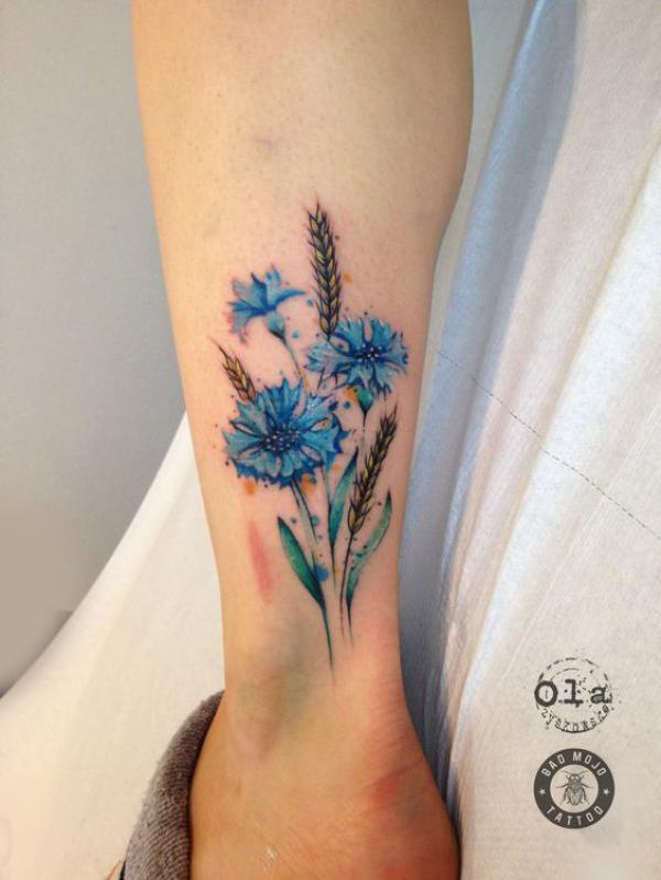 Cornflower and ears of wheat above ankle tattoo