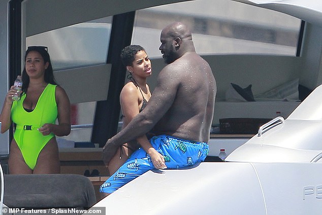 Hug: The LA Lakers icon, 47, dressed shirtless in a pair of electric blue turtle-print swimming trunks as he hugged a bikini-clad beauty on the luxury train