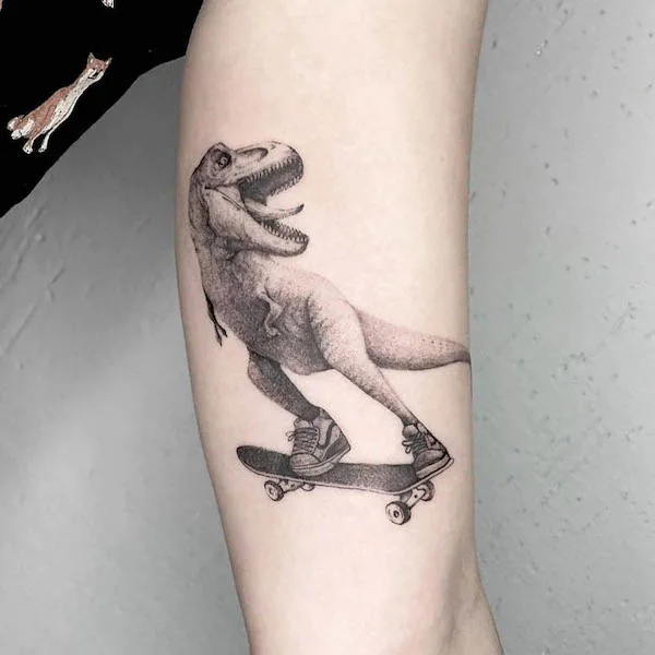 The skating T-rex inner arm tattoo by @lebedtattooing