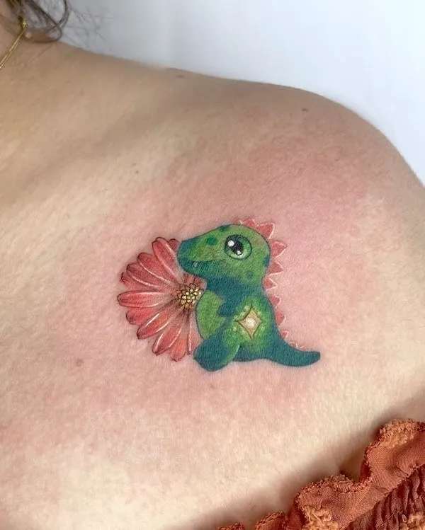 Baby dinosaur and flower tattoo on the shoulder by @azu.tattoo