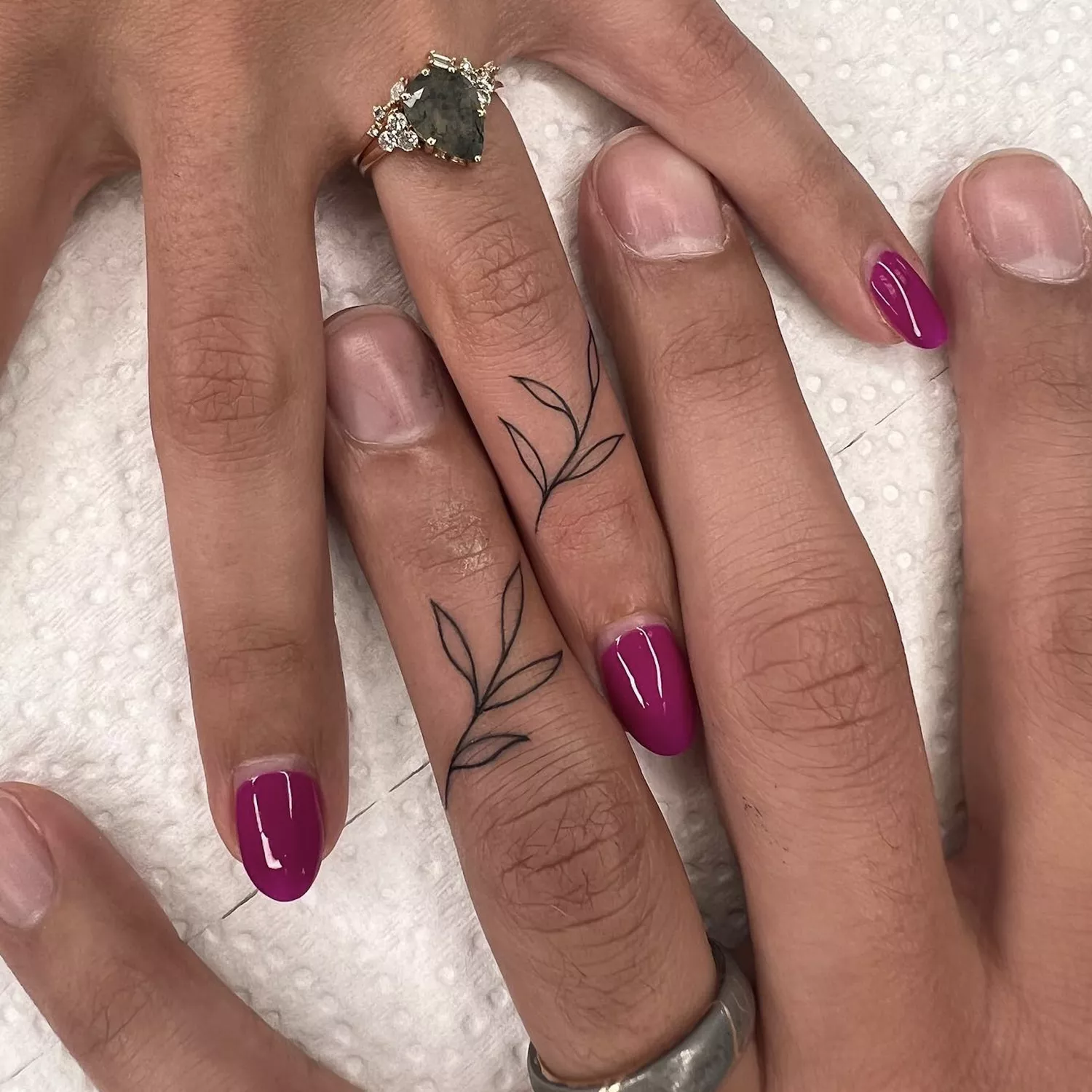 Couple with crawling vine ring finger tattoos