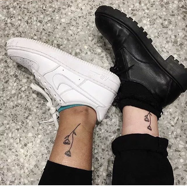 Close up of two ankles with matching flower tattoos