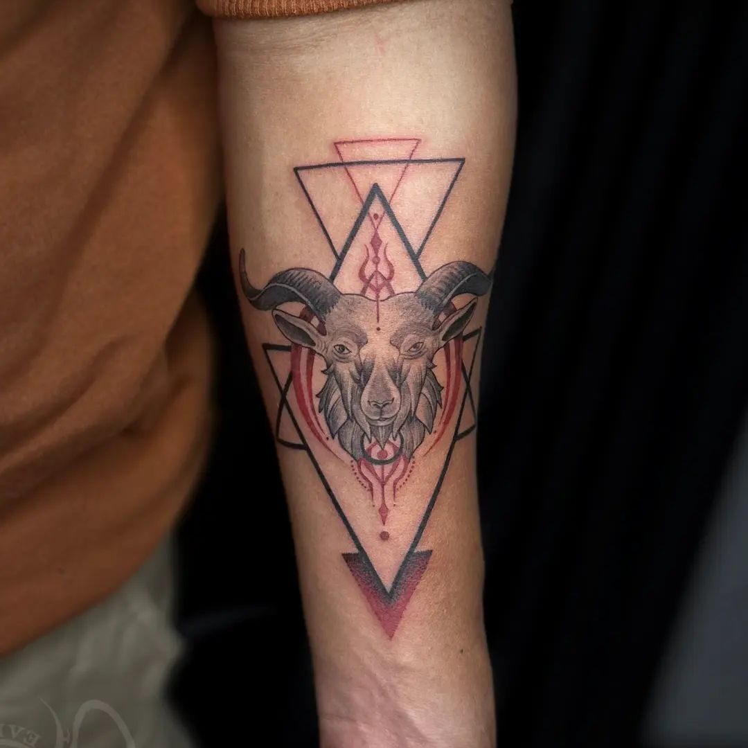 Black and red inked sea goat tattoo on the inner forearm