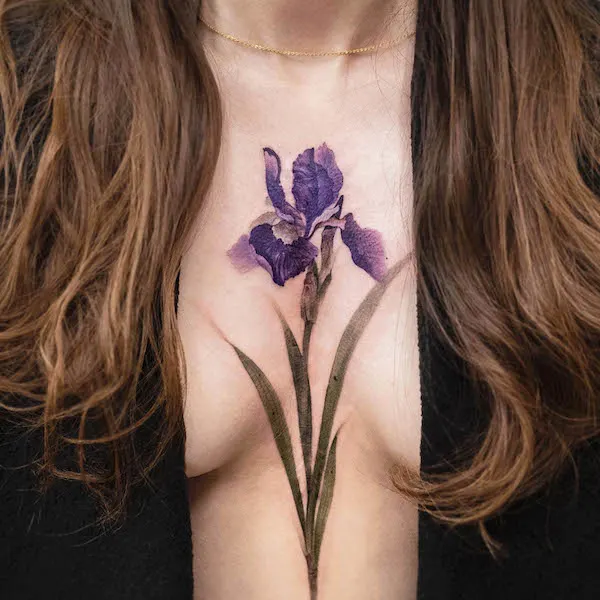 Bold purple flower chest tattoo by @chenjie.newtattoo