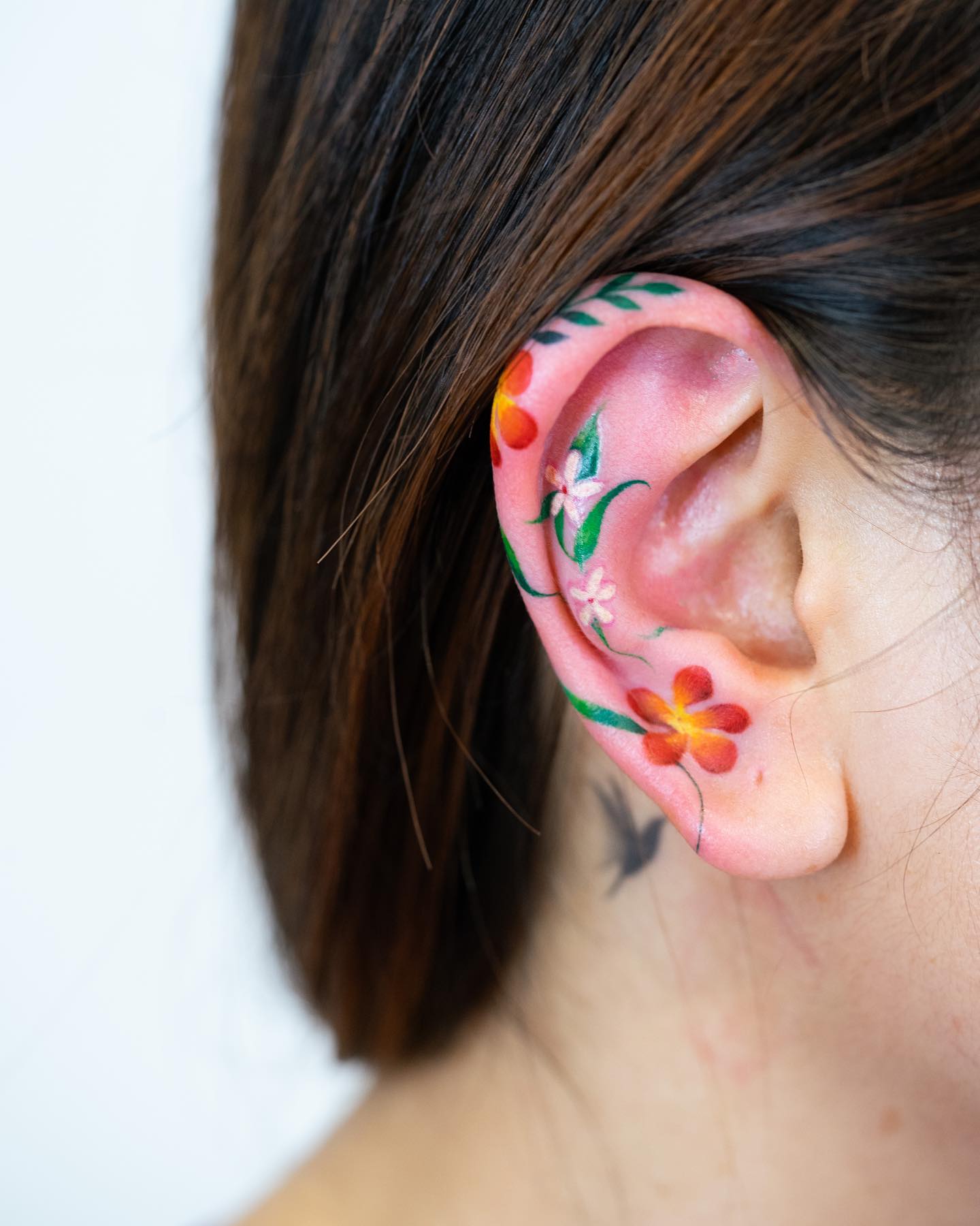 Colorful floral ear tattoo