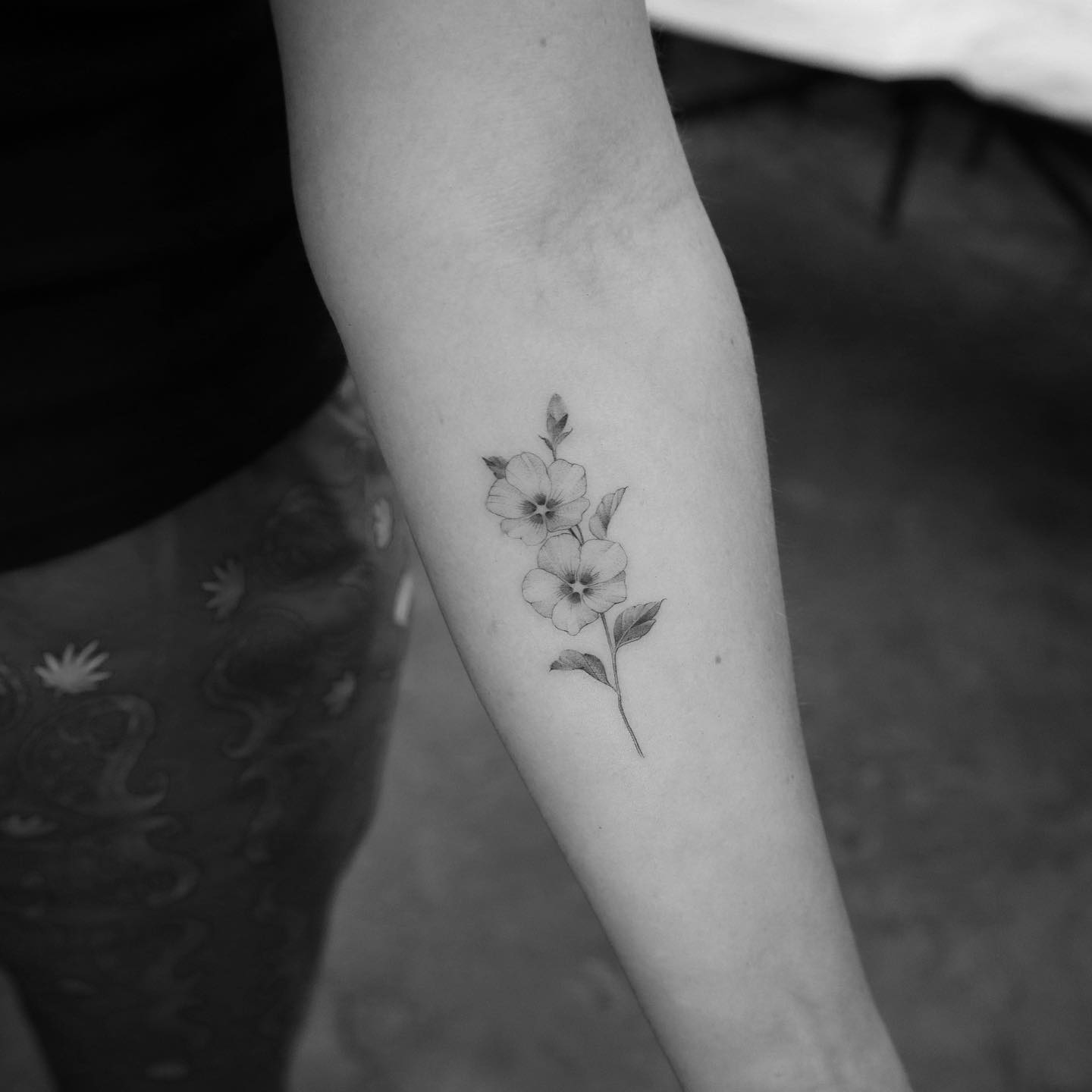 Illustrative style flowers tattoo located on the inner forearm