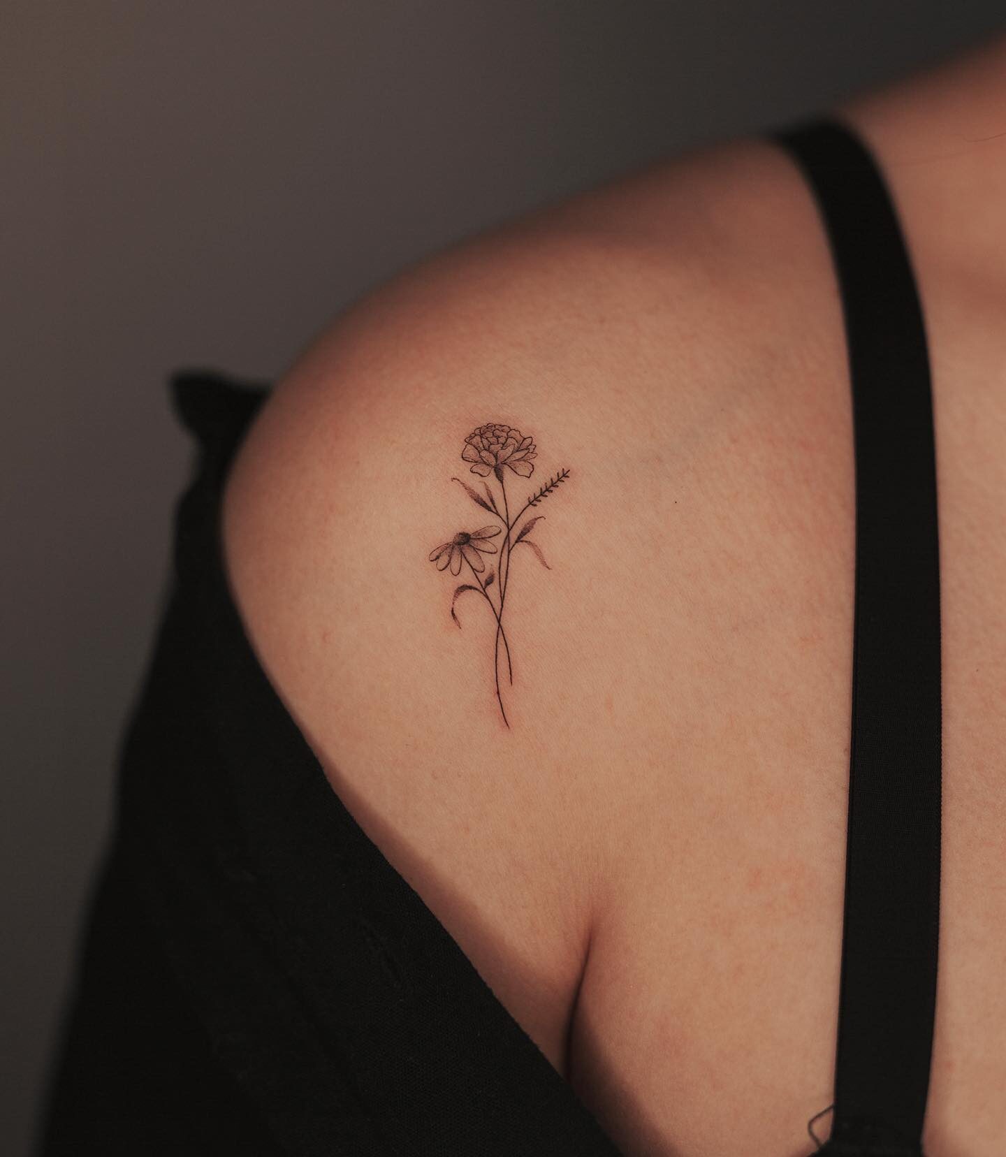 Illustrative style flower tattoo located on the shoulder