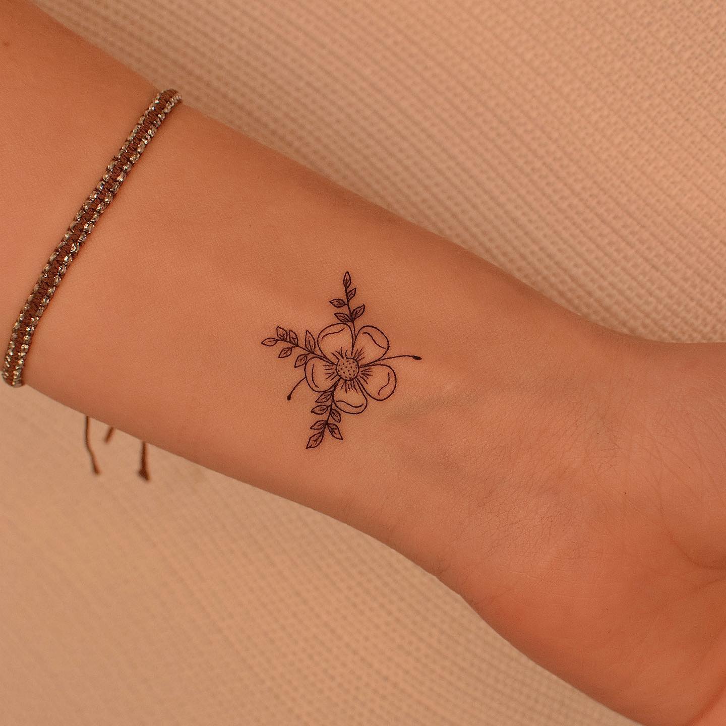 Black inked flower tattoo on the wrist