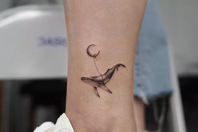 whale tied to crescent moon tattoo