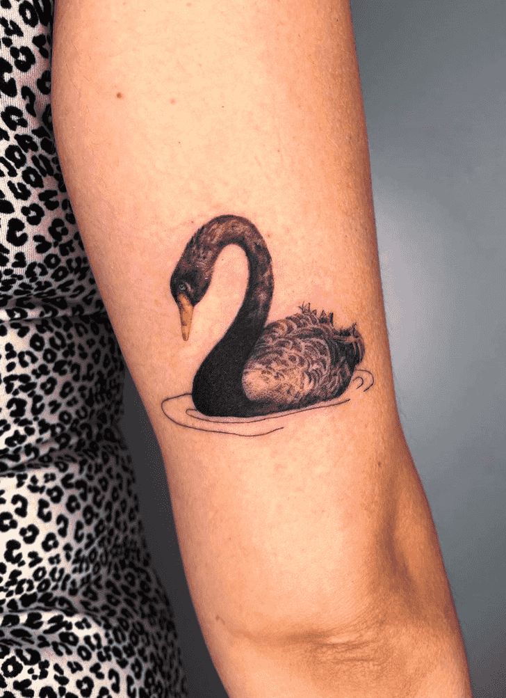This may contain: a woman's arm with a small tattoo of a swan and her baby bird