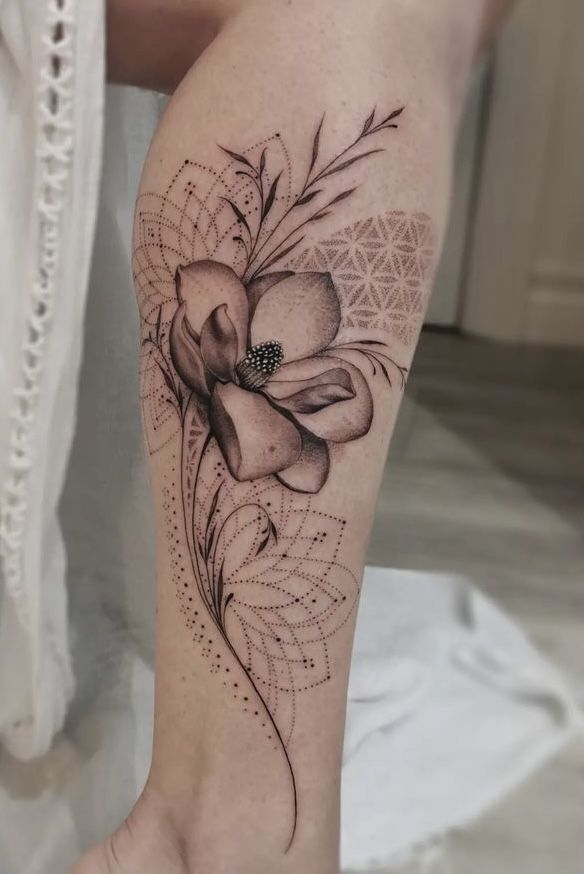 This may contain: a woman's leg with a flower tattoo on it