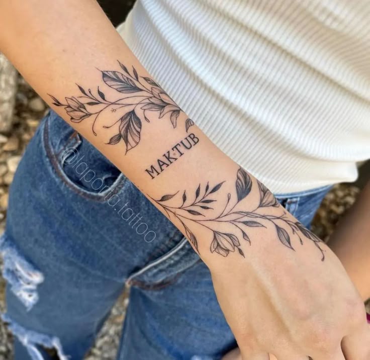 This may contain: a woman with a tattoo on her arm that reads matuu and has leaves around it