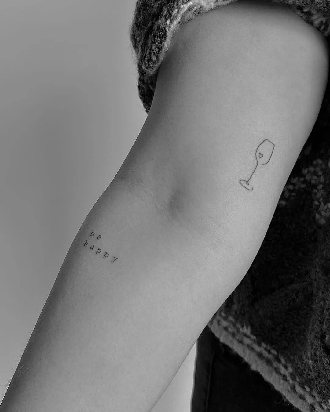 Person shows off a tiny tattoo of a wine glass with a small heart on the inside of their arm