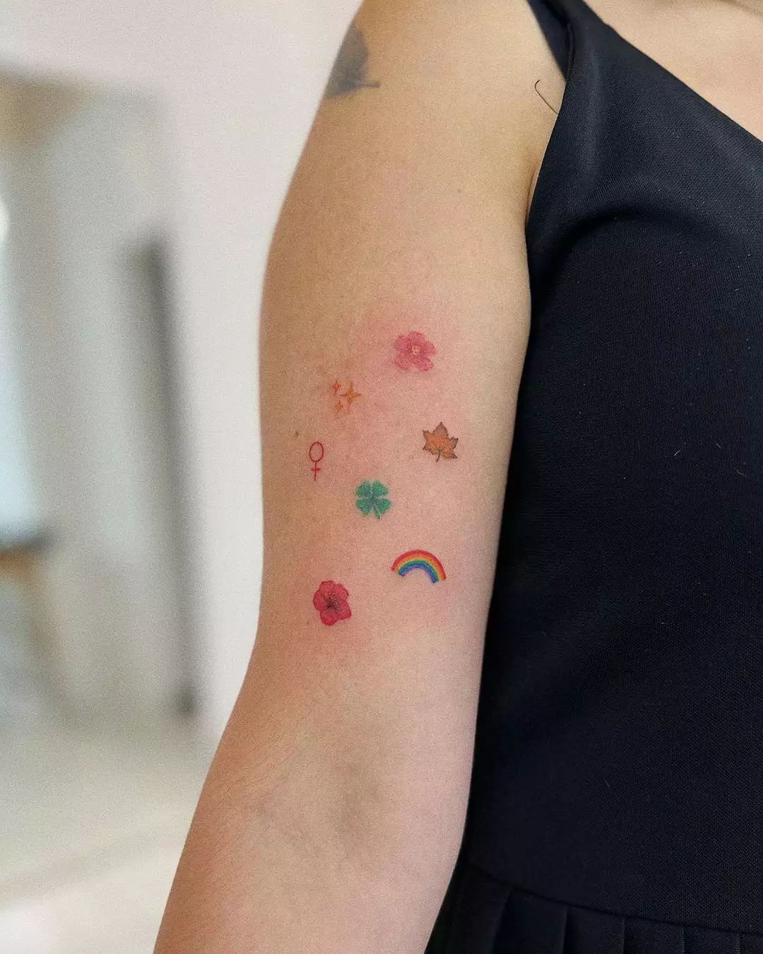 Person shows off an assortment of cute tiny tattoos in different colors and shapes