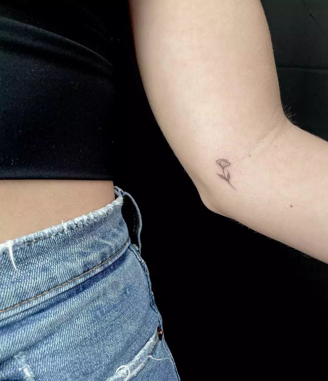 Person showing off the tiny tattoo on the inside of their arm, which is of a fragile flower